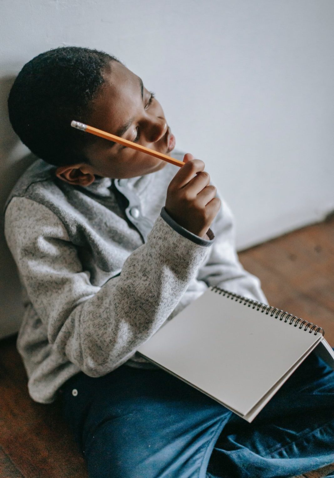 Boy thinking while writing in a notebook